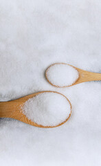 White Refined Sugar on Spoon. Unhealthy Sweet Taste. Table Top View. Vertical image with White copy space