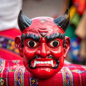 Red demon mask with horns, fangs, and striking features