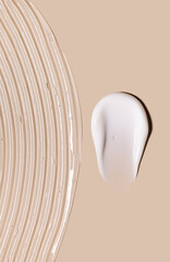 samples of cosmetic care products smear of cream gel texture on a beige background