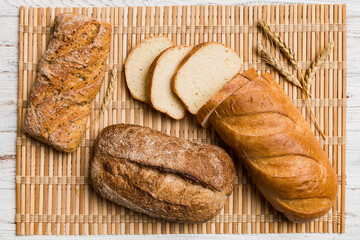 Freshly baked bread slices on napkin against natural background. top view Sliced bread