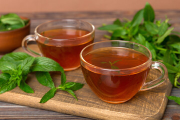 Cup of mint tea on table background. Green tea with fresh mint top view with copy space