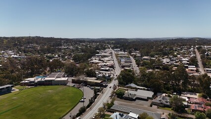 Fototapeta premium Clare, South Australia – Aerial Drone Image of Clare Valley Township Featuring Main Street, Green Parks, Sports Oval, Houses, Estates, and Rolling Hills in the Renowned Wine Region