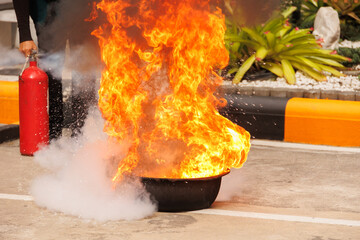 Firefighters use Fire extinguisher spraying chemical liquid fog gas to flame fire extinguishing