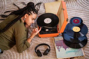 girl turns on a vinyl record player. Vintage sound system .