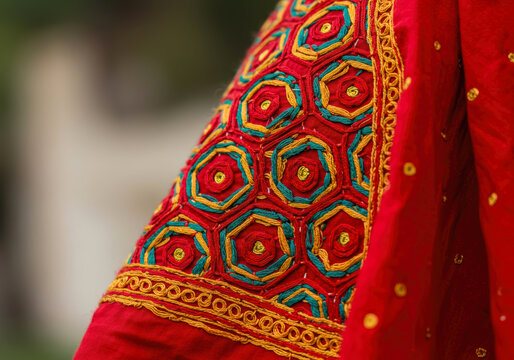 Vibrant Phulkari Embroidery Detail from Punjab, India: Intricate Geometric Silk Thread Patterns on a Rich Red Dupatta Fabric.