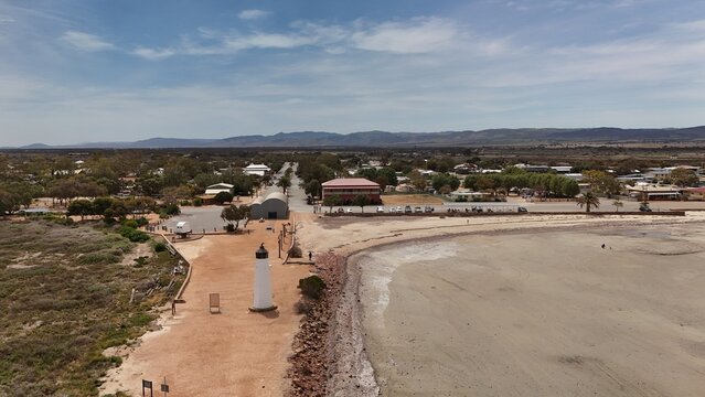 Port Germein, South Australia – Aerial Drone Image of Coastal Town, Historic Lighthouse, Sandy Foreshore, Beachfront Houses, Estates, and Distant Flinders Ranges under a Clear Blue Sky