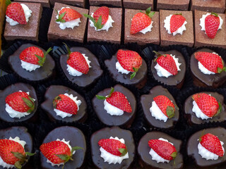 Assorted chocolate desserts with strawberries and cream frosting