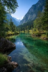 Fototapeta premium Serene Emerald River Winding Through Majestic Alpine Valley Under Clear Blue Sky.