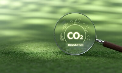 Magnifying glass highlighting CO2 reduction eco symbol on green grass, ideal for promoting sustainability concepts and environmental awareness campaigns