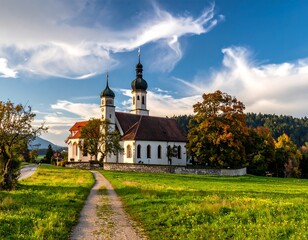 Rural church with twin steeples on green field under a bright cloudy sky, path leads to it