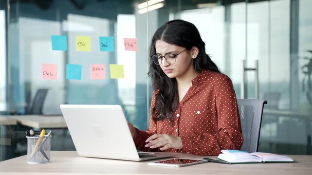 Worried young businesswoman having problems with software or service on laptop computer sitting at workplace in business office. Frustrated disappointed female worker has difficulties with the task