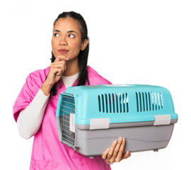 Young Filipina vet holding pet carrier looking sideways with doubtful and skeptical expression.