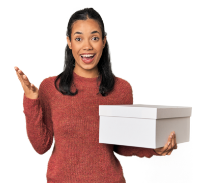 Young Filipina holding a box receiving a pleasant surprise, excited and raising hands.