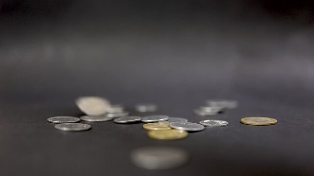 Variety of metallic currency pieces scattered symbolizing wealth creation and savings