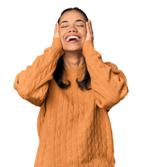 Young Filipina woman laughs joyfully keeping hands on head. Happiness concept.
