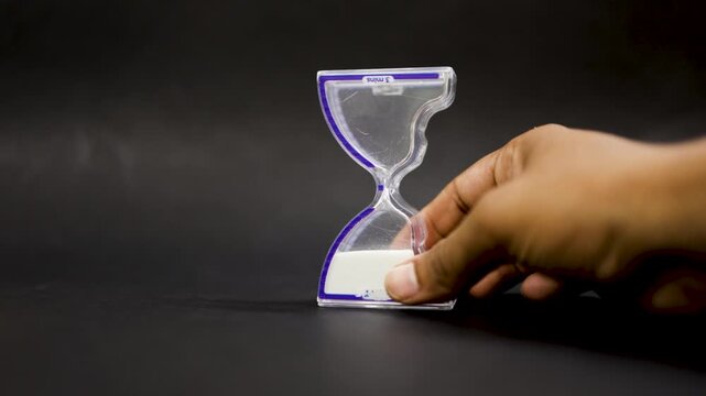 time discipline concept with hand flipping glass sand timer