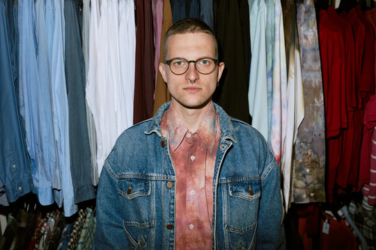 Portrait of person in denim jacket at vintage thrift shop looking at camera