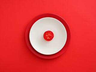 Red tomato slice on white plate minimalist design