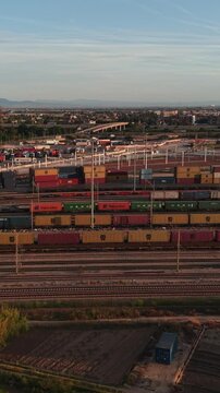Freight train yard with colorful cargo containers at dawn, showcasing logistics and transportation