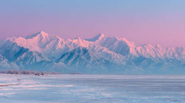 Majestic snow-capped mountain range dramatically framed by a gradient sky with a soft blend of pastel blue and pink hues, creating a serene and tranquil landscape over a frozen lake and shore,...