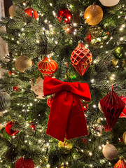 Close-up of a decorated Christmas tree with sparkling ornaments and warm lights. Festive and cozy holiday atmosphere symbolizing Christmas celebration, family traditions, and winter mood.