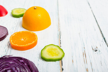 sliced fruit and vegetable circles on white wood table