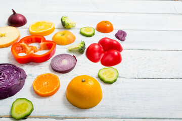 sliced fruit and vegetable circles on white wood table
