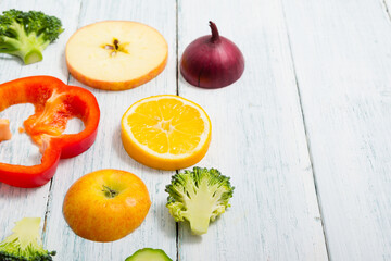 sliced fruit and vegetable circles on white wood table