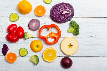 sliced fruit and vegetable circles on white wood table