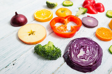 sliced fruit and vegetable circles on white wood table