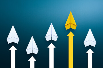 Yellow paper plane leading among a white planes and arrow up, Business competition concept.