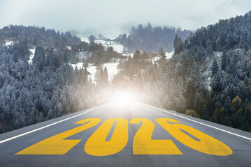Straight road leading into snowy forest mountains with large text number 2026. Perfect for business strategy, achievement, planning, and creative projects about new beginnings and opportunities