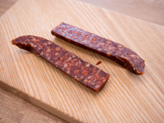 Traditional pork sausage sliced on a wooden cutting board. Smoked homemade delicacy from pig slaughter, typical for Easter and Central European cuisine.