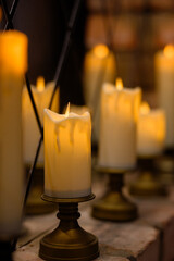 Row of warm yellow LED candles in candle holders for event decor in the dark