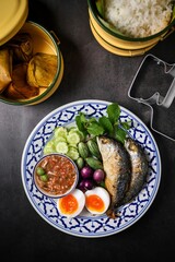 A set of thai cuisine shrimp paste dip with fried mackerel ,soft boiled eggs and set of vegetables