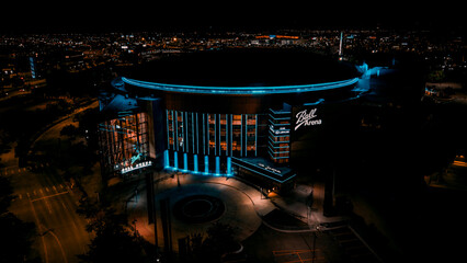 Aerial view of the luminous Ball Arena stands brightly against the dark sky, a beacon in the night, Denver, Colorado, United States.
