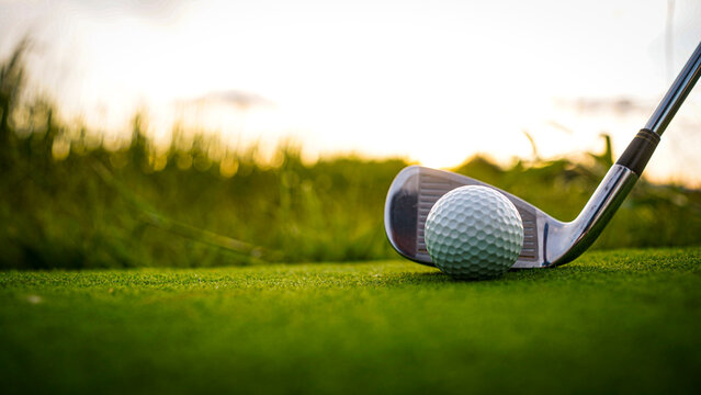 Golf clubs and balls on a green lawn in a beautiful golf course with morning sunshine. - Powered by Adobe