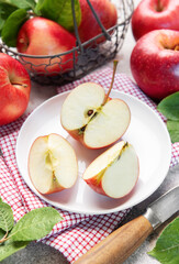 Fresh red apples in basket and sliced on plate