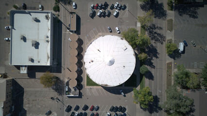 Aerial view of a circular building with a white roof surrounded by parking spaces, adjacent to a rectangular building, Greeley, Colorado, United States.