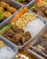Catering meal boxes filled with spiced braised beef, vermicelli noodles, bean sprouts, and lime slices — ideal for menus, packaging, catering promotions, and meal-prep visuals
