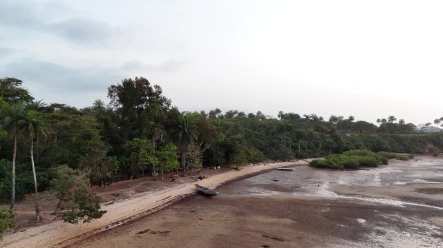 Aerial view of turquoise bay and rocky shore with tropical palm tree beach in Bijagos Islands, Guinea Bissau, west African coastline drone footage