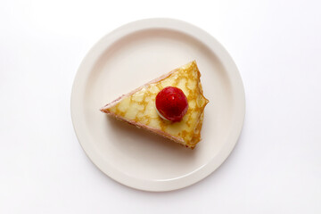 A slice of crepe cake topped with strawberries