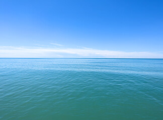 Blue sea water background and sun reflections.. Waves water surface with blue sky background