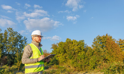 Male engineer inspects the condition of a new construction site. Work forestry inspector, environmental control. Ecologist conducts environmental monitoring soil analysis. 