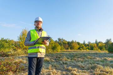 Male engineer inspects the condition of a new construction site. Work forestry inspector, environmental control. Ecologist conducts environmental monitoring soil analysis. 