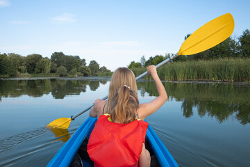 Mother and daughter kayaking on calm river on a sunny summer day, enjoying outdoor adventure and family time together in nature
