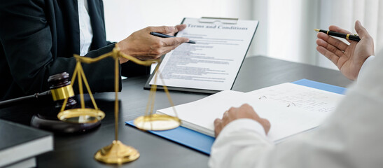 Female lawyer is pointing on legal document to explaining about legal consultation, terms and condition to businessman