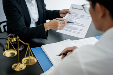 Female lawyer is pointing on legal document to explaining about legal consultation, terms and condition to businessman