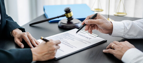 Female lawyer and businessman signing on contract after discussion about terms, condition and legal document