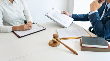 Male lawyer and professional businesswoman working and discussion having at law firm in office, Judge gavel with scales of justice